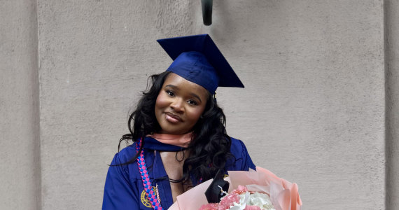 Chizoba in her graduate cap and gown with a bouquet of flowers